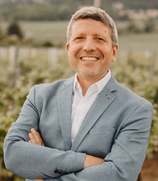 Hauptgeschäftsführer Dirk Gerling lächelnd vor Weinreben